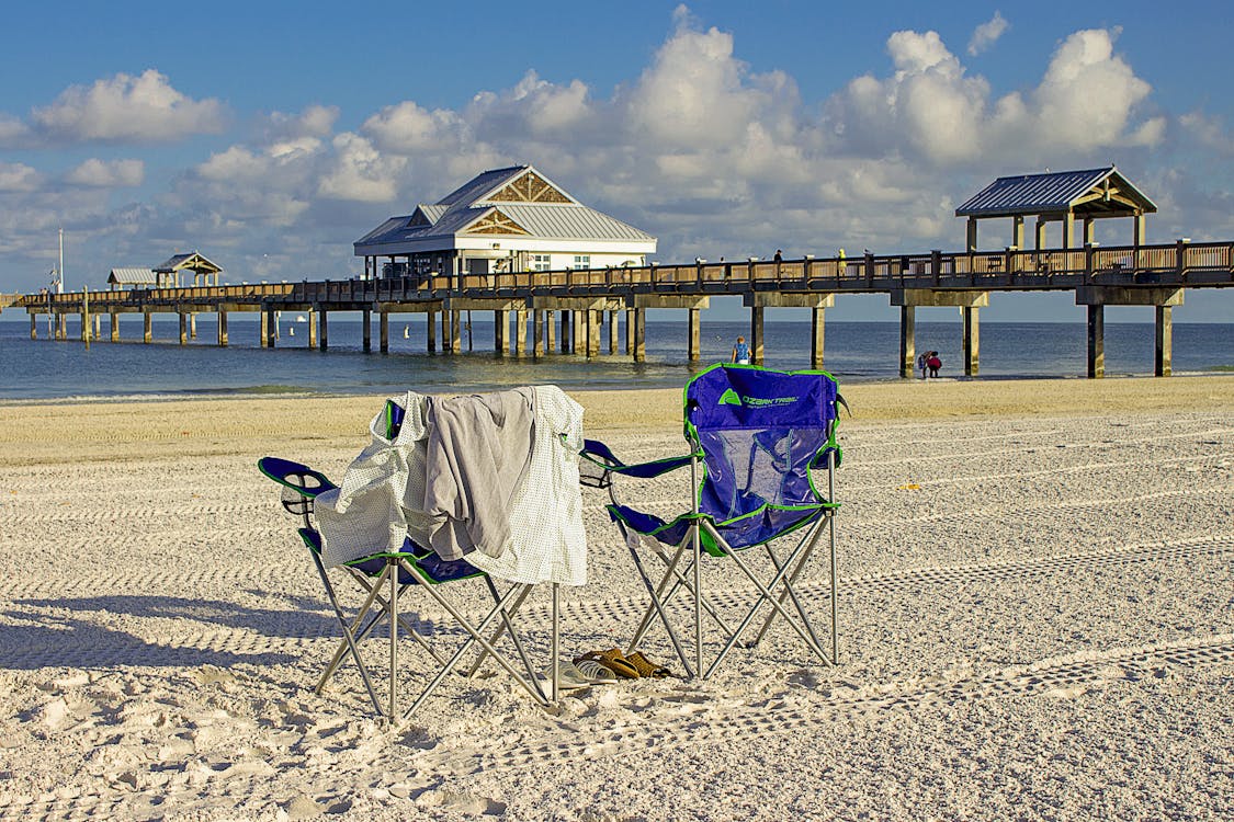 Beach chairs facing Pier 60 on Clearwater Beach, white sand and turquoise Gulf water